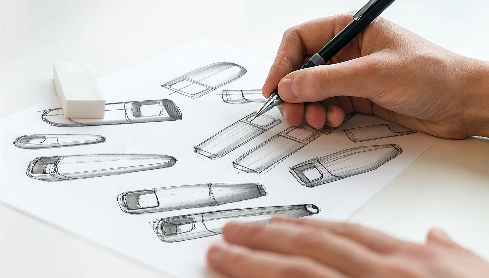 Designer sketching handheld device concepts in pencil