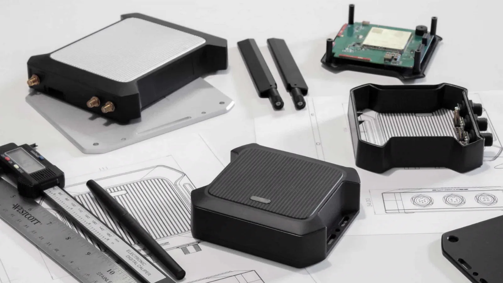 Syncwise GPS device enclosure parts, antennas, and circuit board laid out on a desk