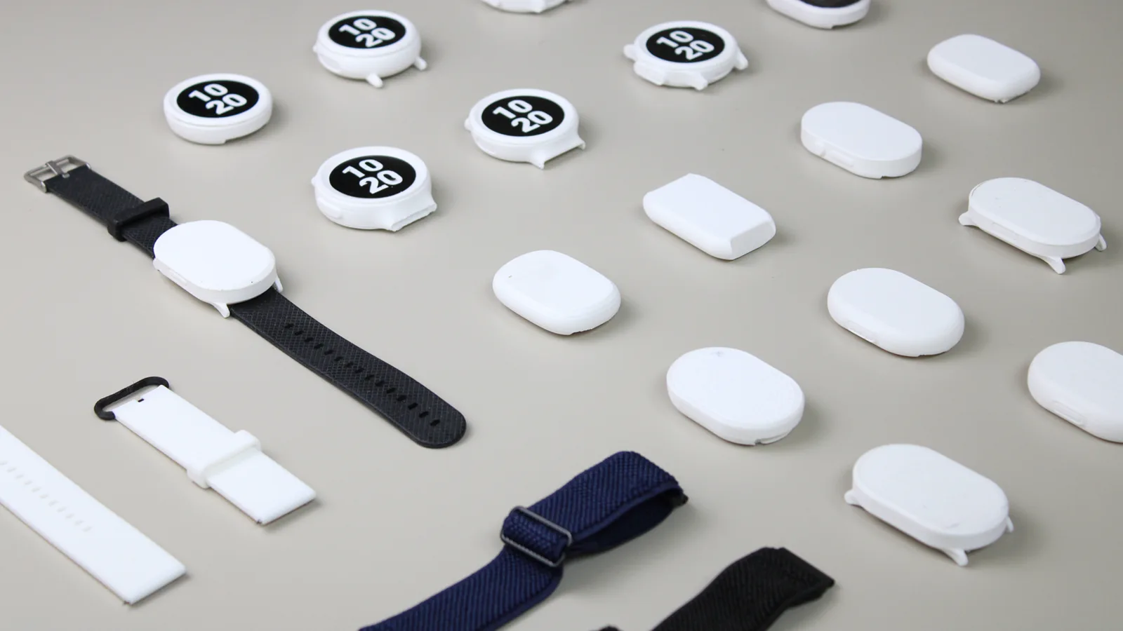 PlayMaker+ watch bodies and straps laid out in a grid