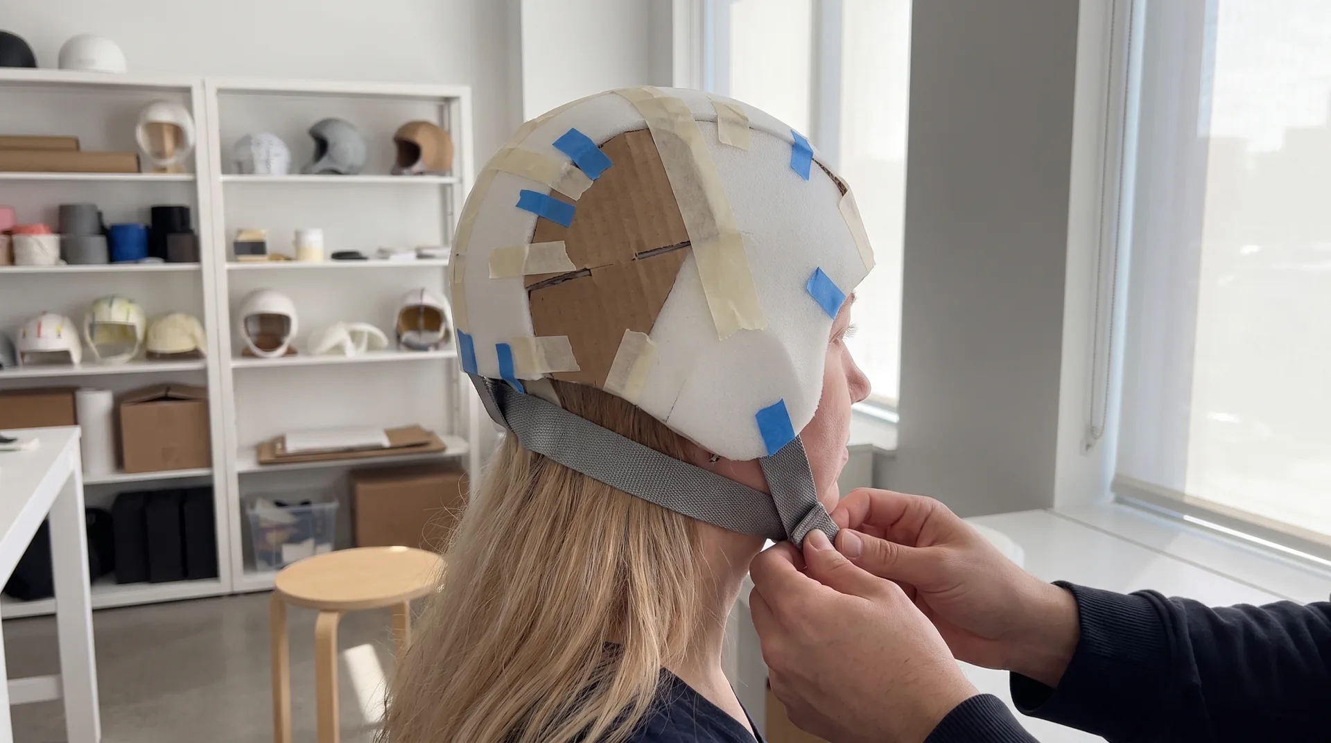 Fitting a cardboard Gentle Care cooling cap prototype on a person