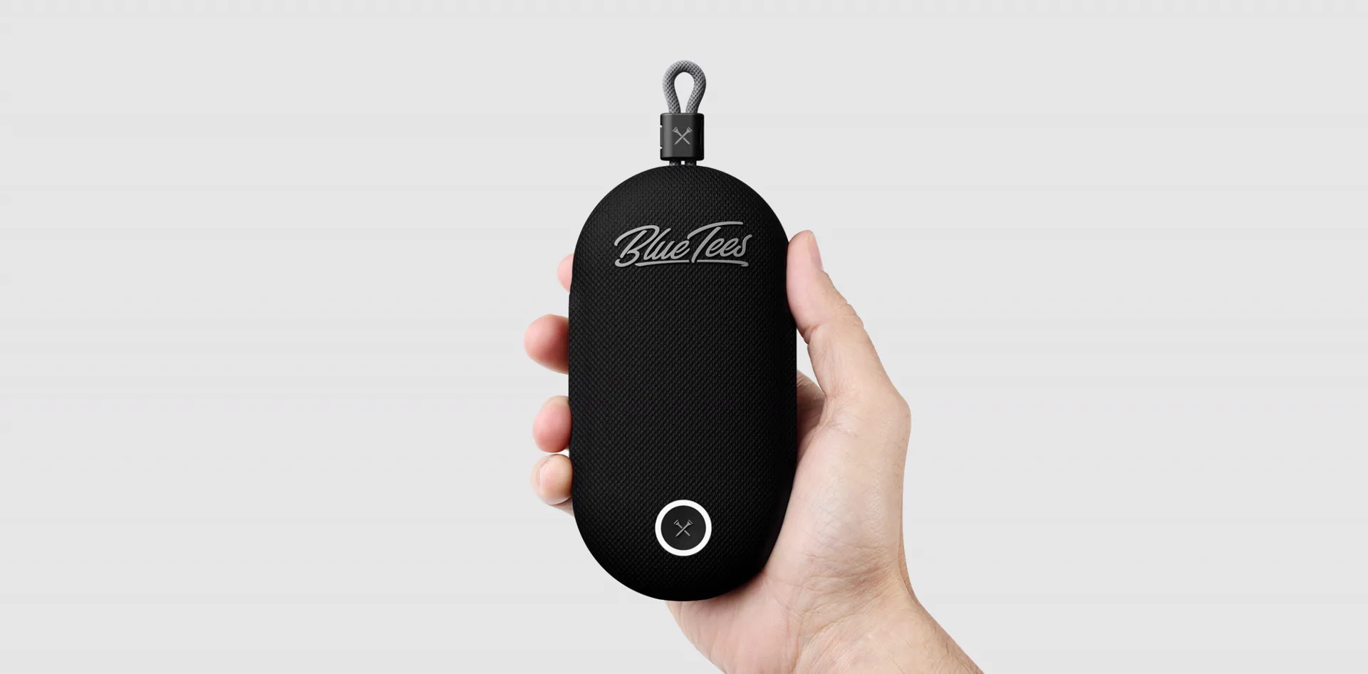 Hand holding the black BlueTees PlayerGo golf GPS speaker