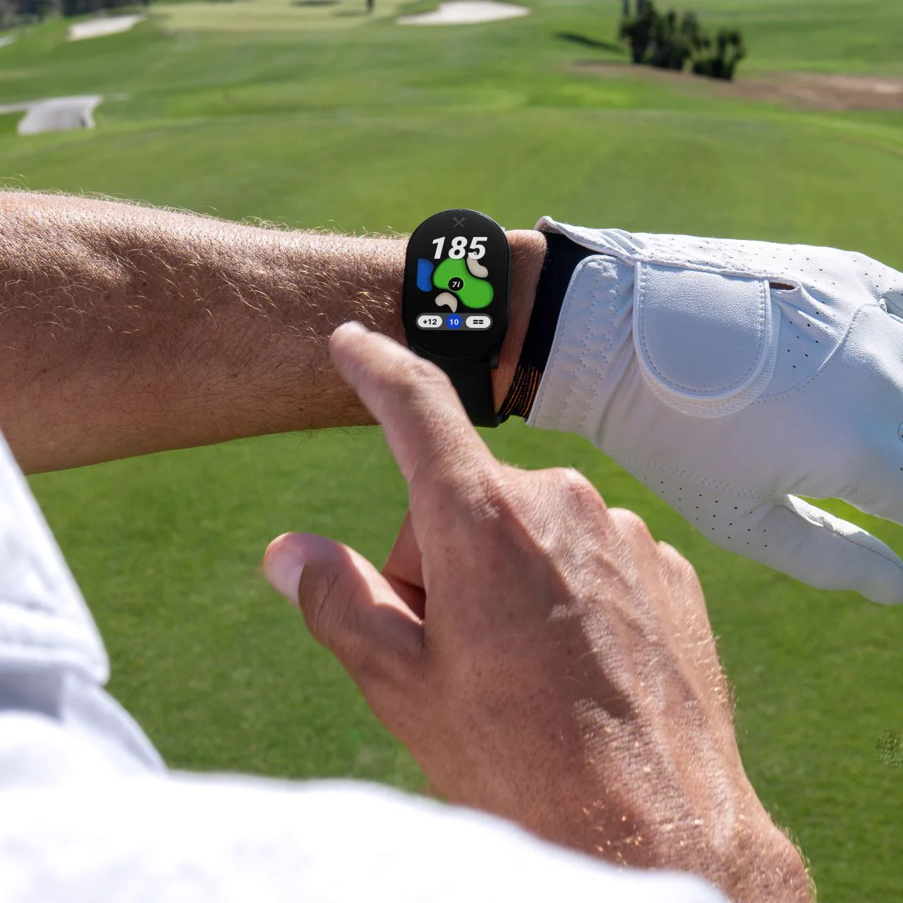 Golfer tapping the PlayMaker+ screen on the course