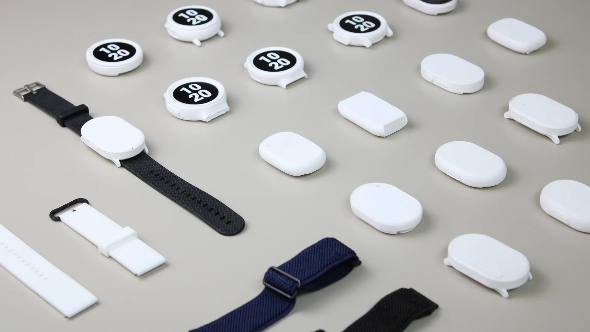 PlayMaker+ watch bodies and straps laid out in a grid