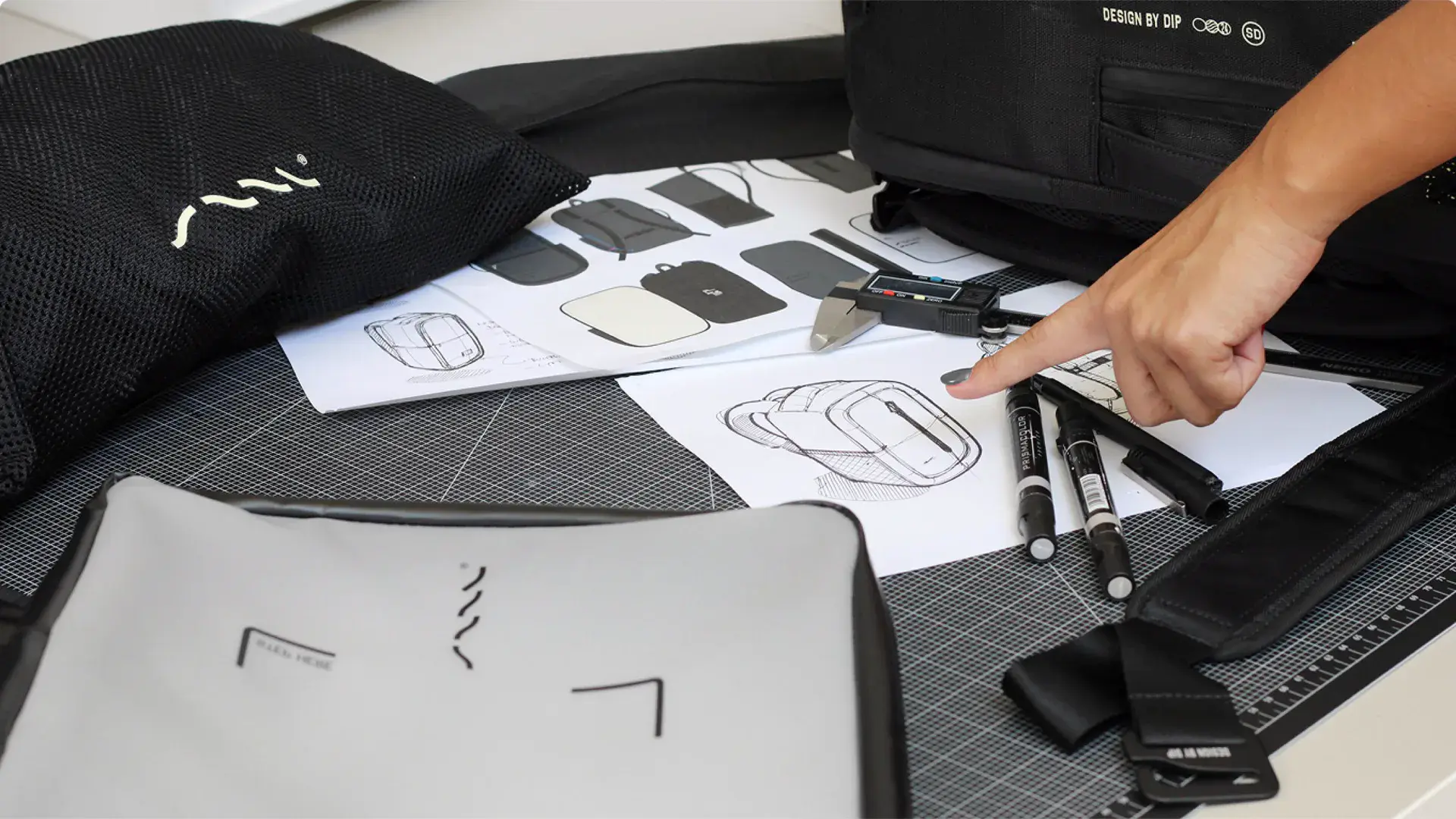 Prototype materials and sketches for the SAAL Surfbag on a workbench